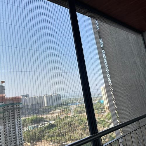 Invisible grill with pleated net on a high-rise balcony
